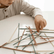 Close up of a child's hand lifting one stick from a scattered pile on a table