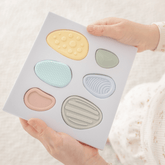 Child holding the open Worry Stones tray with the six textured stones in place