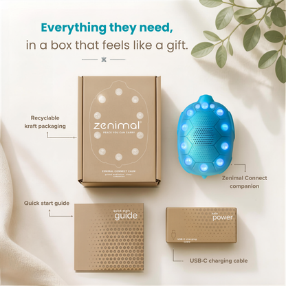 Zenimal wellness set including a kraft paper box, a blue honeycomb-shaped companion device with glowing LED lights, a quick start guide, and a USB-C charging cable on a neutral background with decorative leaves.