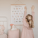 Girl reaching up beside the Yoga Poses print hanging on her bedroom wall