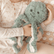 Child in floral pajamas holding the teal weighted octopus on their lap