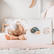 Child in child's pose on a pink rug beside the Clam yoga card