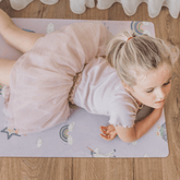 Child in child's pose on the lilac Enchanted mat, seen from above