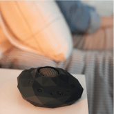 Black Zenimal teen adult device on a white surface with a blurred background