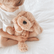 Child sitting on a white bed with the weighted puppy held in their lap