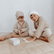 Two children in knitted hats sitting on the floor playing the yoga snap game