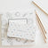The spotted pencil box resting on an open coloring page, with three pencils alongside