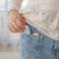 Child tucking a blue worry stone into the pocket of their jeans