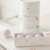 Tube of magnesium calming soak on a counter beside an open box of three lavender bath fizzies.