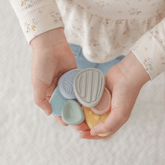 Child holding three textured worry stones in both hands