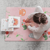 Child sitting cross legged on the pink Sweet mat, seen from above, with yoga cards beside them
