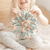 Child holding the closed magic ball in both hands, ready to expand it