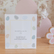 Worry Stones box standing on a wooden shelf beside a pink flower decoration