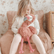 Girl sitting in a chair with the weighted flamingo resting upright in her lap