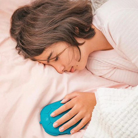 Person lying in bed holding a blue handheld device