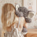 Girl seen from behind carrying the weighted elephant over her shoulder