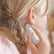 Child rolling the essential oil onto the skin behind their ear