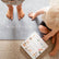 Child's bare feet on the grey yoga mat with a yoga card on the floor beside them