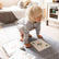 Toddler in downward dog on a grey mat with yoga cards laid out on the floor