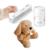 Golden puppy plush with a tube of magnesium calming soak and a hand lifting a bath fizzy from its box.