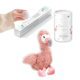 Pink flamingo plush with a tube of magnesium calming soak and a hand lifting a bath fizzy from its box.