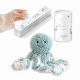 Teal octopus plush beside a tube of Mindful and Co Kids magnesium calming soak, with a hand lifting a bath fizzy from its box.
