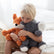Boy sitting on a bed holding the weighted elephant and an orange weighted fox