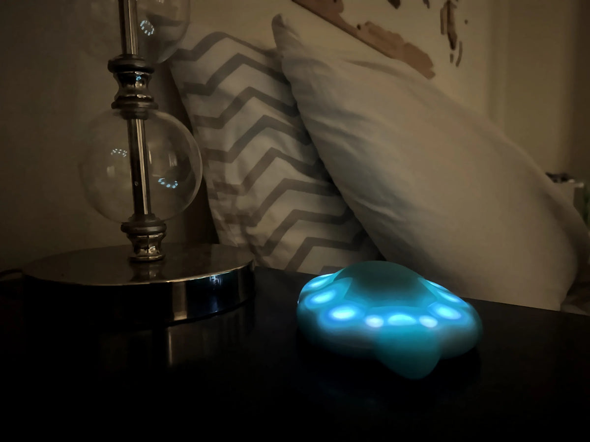 Zenimal Connect glowing softly on a nightstand in a dark bedroom